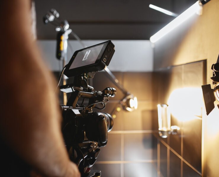 Video production backstage. Behind the scenes of creating video content, a professional team of cameramen with a director filming commercial ads. Video content creation, video creation industry, Low key, selective focus, film graine.